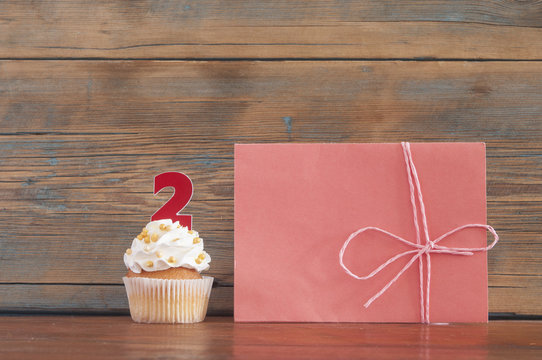 Cupcake and word Love on wooden table.