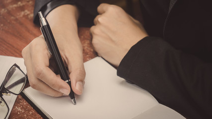 Man hand with pen writing on notebook.