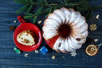 Traditional fruitcake for Christmas decorated with powdered sugar and nuts, raisins. Delicioius Homemade Pastry. New year and Christmas celebration concept