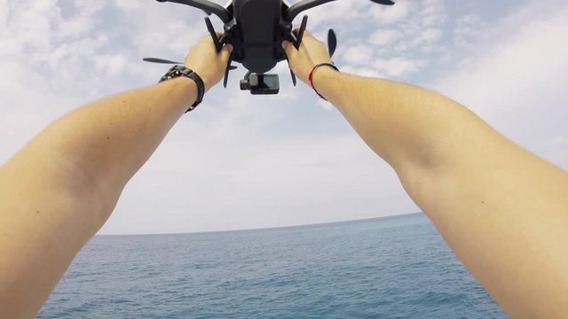 Person holds drone on boat, POV