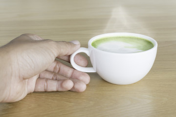 Hot Green tea mail cup,Matcha latte and beans on wooden table, in the morning