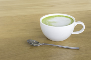 Hot Green tea mail cup,Matcha latte and beans on wooden table, in the morning