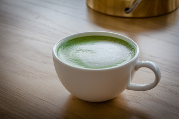 Hot Green tea mail cup,Matcha latte and beans on wooden table, in the morning