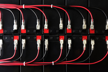 Battery powered. Industrial battery hooked up in parallel with red and black cable bundles, coming...