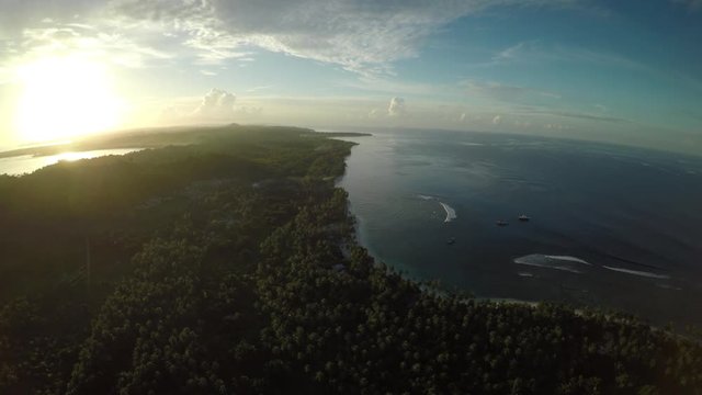Sun sets over vast island landscape, aerial
