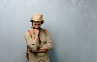 young traveler man or tourist With a confused and thoughtful look, looking sideways, thinking and...
