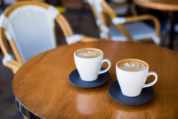Cups of cappuccino with latte on wodden table.