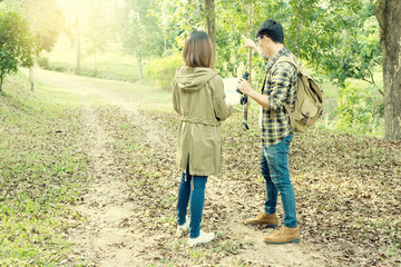 man and woman walk in the forest