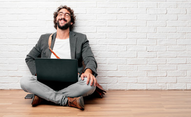 young man sitting on the floor Laughing out loud with head tilted backwards and happy, cheerful expression