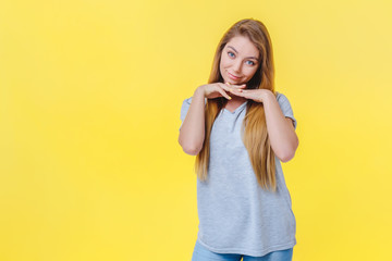 Cute girl on a yellow background trying to charm the interlocutor.