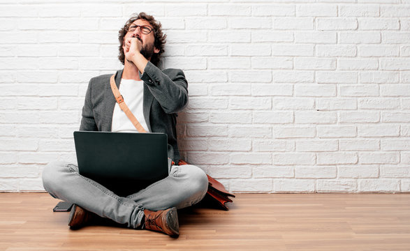 young man sitting on the floor Coughing, suffering a winter illness such as a cold or the flu, feeling unwell and feverish.