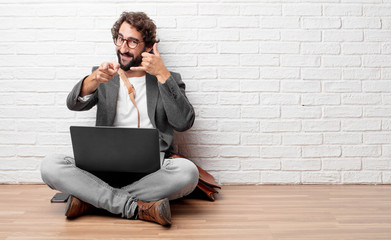 young man sitting on the floor making a phone call gesture or sign, with a proud, happy, satisfied...