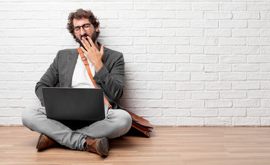 young man sitting on the floor Looking unenthusiastic and bored, listening to something dull and...