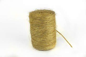 Spool of light brown hemp twine on white background