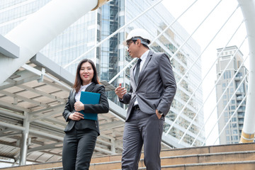 Asian engineer was acting with his secretary on the Business building background.