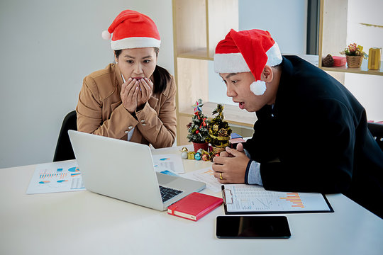  Group of young business people are sitting in Santa hats in last working day. young creative people are celebrating holiday in modern office. Merry Christmas and Happy New Year 2018