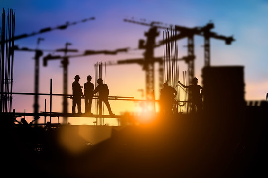 Silhouette of engineer and construction team working at site over blurred background for industry background with Light fair.Create from multiple reference images together