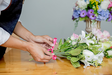 Obraz na płótnie Canvas Woman hands making flower composition at florist workshop. Do it yourself concept