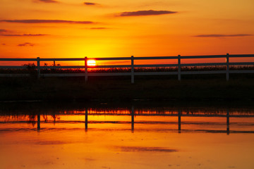 Sunset over the fence and lake