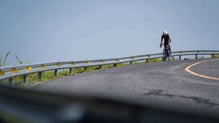 Naklejka na ściany i meble Asian man cycling road bike in the morning