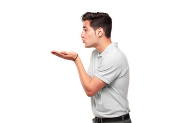 Young handsome tanned man sending a flying true love kiss, showing care, fondness and affection; a...