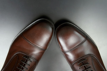 Classic men's brown Oxford shoes on dark background