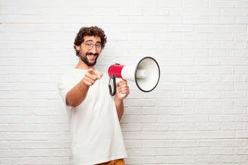 young dumb man smiling happily and pointing forward, choosing you.