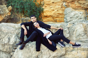 Fashionable young couple on the rocks .A young couple in love in the country .The concept of fashionable clothes