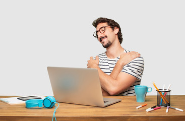 young bearded graphic designer with a laptop with a proud, confident and happy look, smiling and...