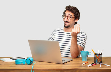 young bearded graphic designer with a laptop looking happy, proud and satisfied, gesturing cash or...