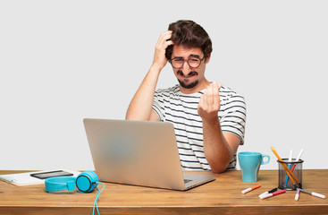 young bearded graphic designer with a laptop looking sad and worried, absolutely empty-handed,...