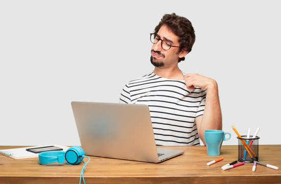 young bearded graphic designer with a laptop with an anxious, stressed and nervous gesture, feeling under great pressure.
