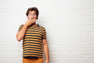 young dumb man Covering mouth with hand with a gesture of surprise, in order to remain silent and...