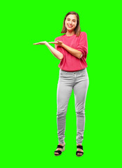 young woman full body. smiling with a satisfied expression showing an object or concept with both...