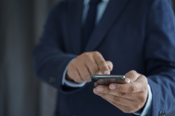 Business man hold the smartphone on the street  and copy space.