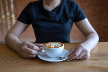 Closeup of hands Young woman holding a cup of coffee  in a cafe
