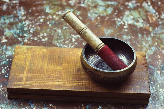 Tibetan bowl with stick on wooden board