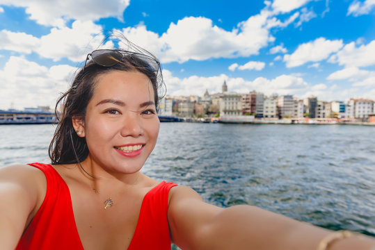 Beautiful woman takes selfie with view of Galata Tower