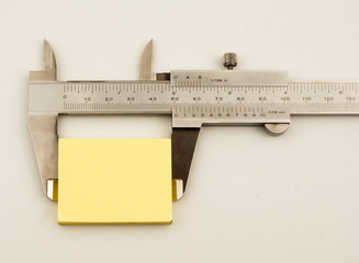 Vernier caliper and yellow note on white background
