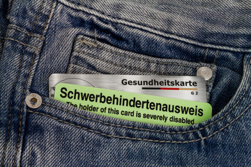 Schwerbehindertenausweis und Gesundheitskarte in einer Hosentasche