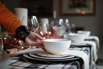 woman's hand setting a table for thanksgiving dinner