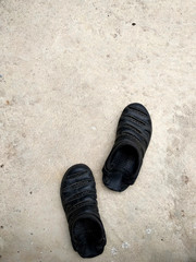  Black rubber sandals isolated on the white concrete background with shadow.Black rubber sandals isolated on the white concrete background with shadow.