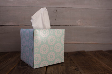 a box with napkins on wooden background