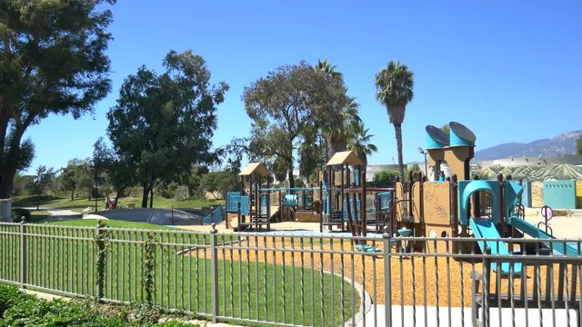 An empty playground for children in the middle of a park near the beach on a sunny day in Santa Barbara, California.