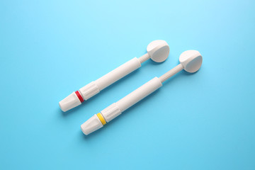 Syringes of resin luting cement on color background