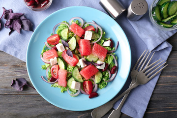 Plate with delicious watermelon salad on wooden table