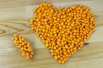 Sea buckthorn in the shape of a heart on a table