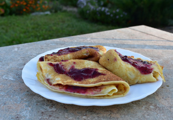 Pancakes with jam on a white  table.