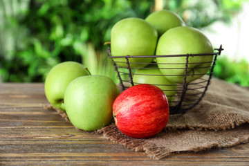 Basket with ripe fresh apples on wooden table