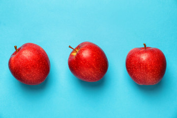 Ripe red apples on color background